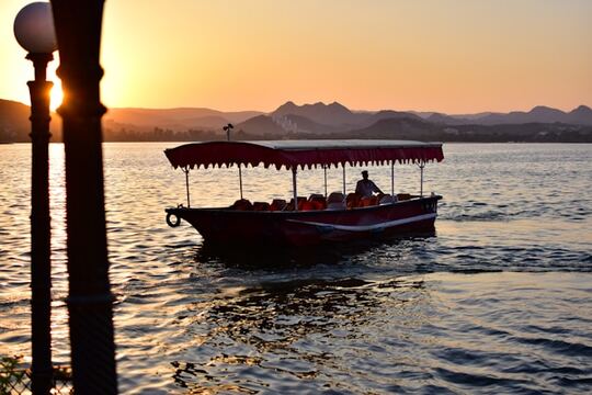 Visitors enjoying a scenic boat ride on Lake Pichola in Udaipur, Rajasthan.
